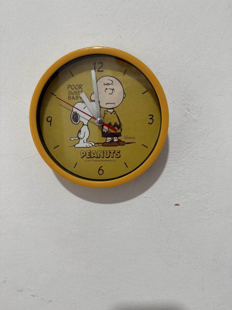 Peanuts Charlie Brown Snoopy Yellow Wall Clock 2017 (Category: Clocks) located in Valenzuela. Submitted by joy_2da_world (Listing ID 1458542706, Image 1). Description: - Yellow wall clock featuring Charlie Brown and Snoopy - Text reads 'POOR SWEET BABY' - Made by Peanuts Worldwide LLC in 2017 - Quartz movement - Approximately 8 inches in diameter - Ideal for any Peanuts fan's room.