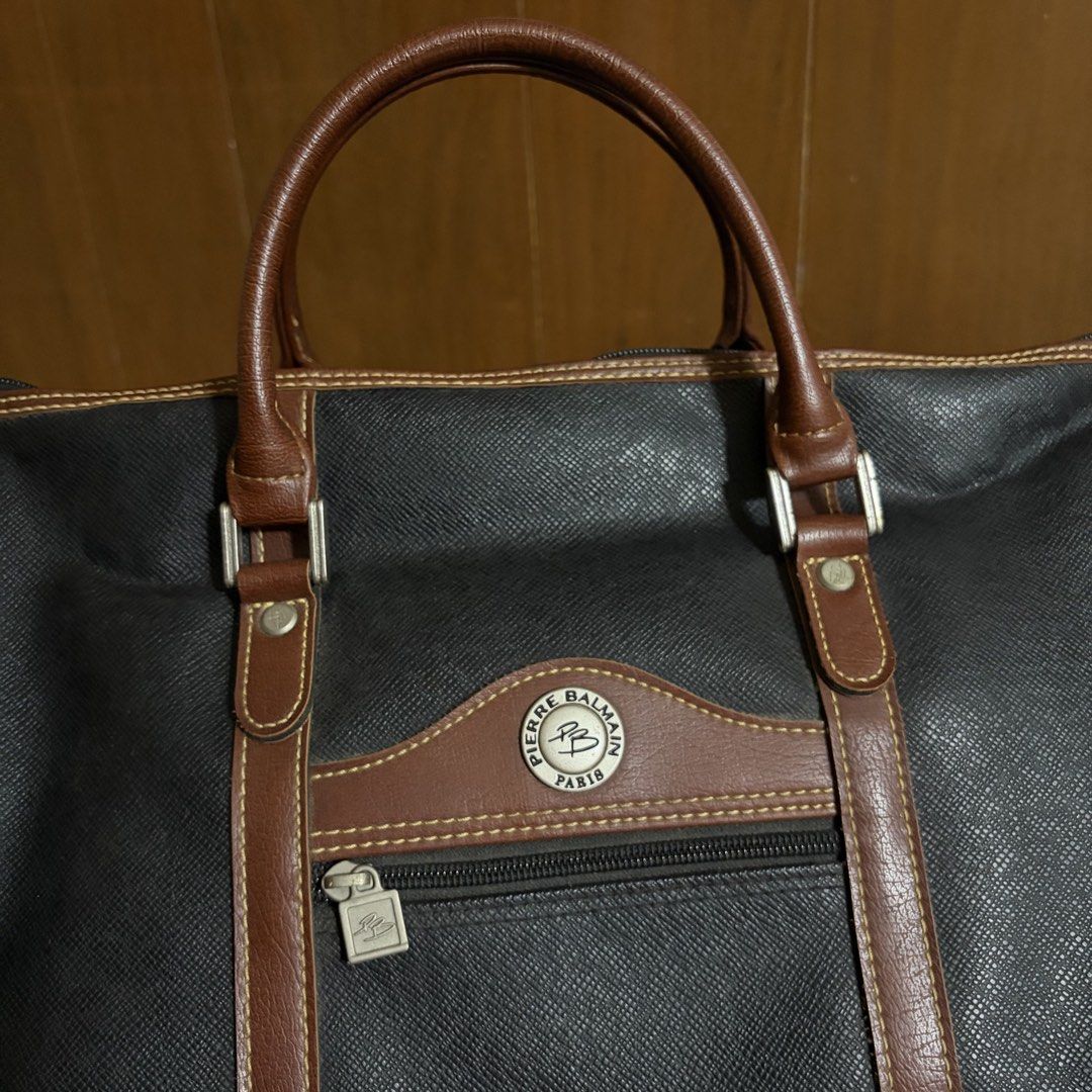 Pierre Balmain Paris Black Leather Duffle Bag (Category: Luxury Bags & Wallets) located in Quezon City. Submitted by slightlymawts (Listing ID 1458549924, Image 3). Description: - Classic black duffle bag by Pierre Balmain - Features brown leather trim and handles - Zippered front pocket - Main zippered compartment - Ideal for weekend trips or carry-on luggage - Vintage quality - Rarely used RFS: decluttering .