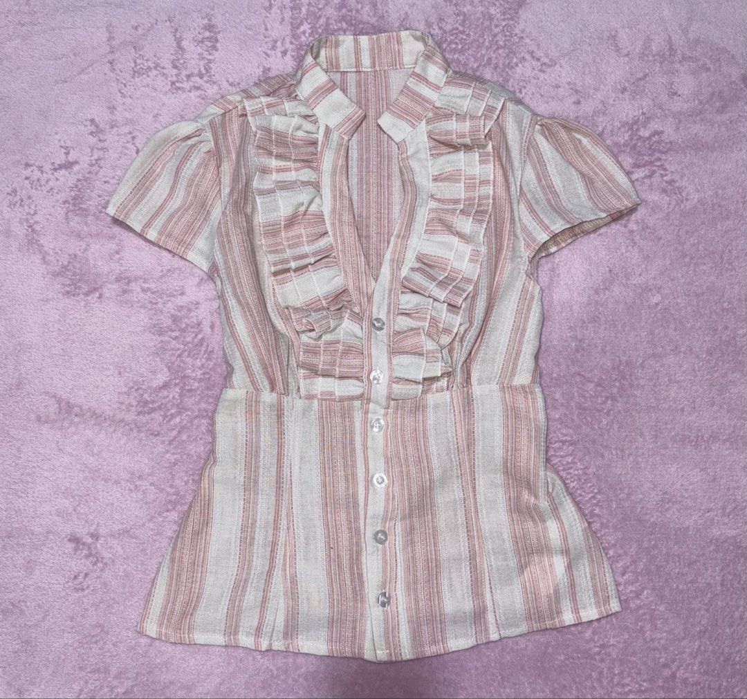 Pink and White Striped Ruffle Button-Up Blouse (Category: Blouses) located in Quezon City. Submitted by luna_ily (Listing ID 1458614794, Image 1). Description: 🍒 Retail price is ₱500. 🍒 Condition: Brand new. Only fit once. 🍒 Comes with a tie to cinch the waist. 🍒 Don’t hesitate to send a message for further details and inquiries. Location: Cubao, Quezon City Mode of delivery: J&T and Lalamove (shipping fee will be shouldered by the buyer) Mod