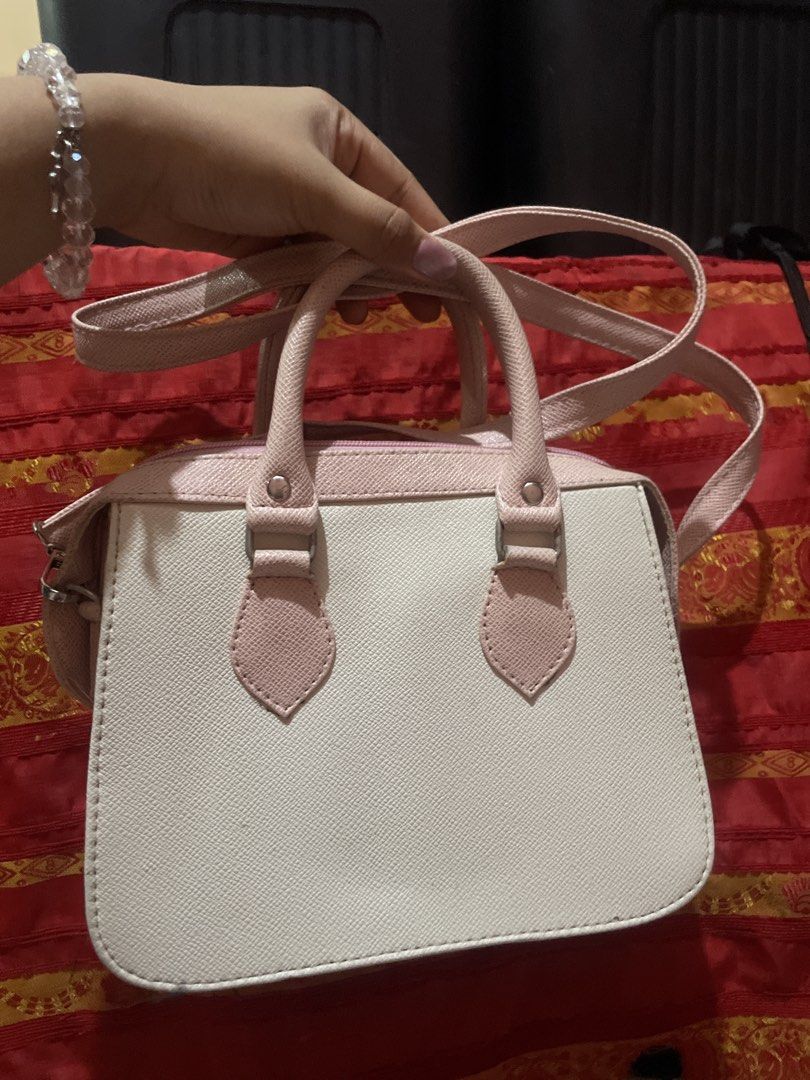 Pink and White Structured Handbag with Shoulder Strap (Category: Shoulder Bags) located in Taguig. Submitted by prelovedttuh (Listing ID 1458648620, Image 2). Description: - Cute pink and white handbag - Structured design with top handles - Includes a detachable shoulder strap - Features a lovely textured material - Spacious interior for all your essentials - Versatile for everyday use or evening outings.