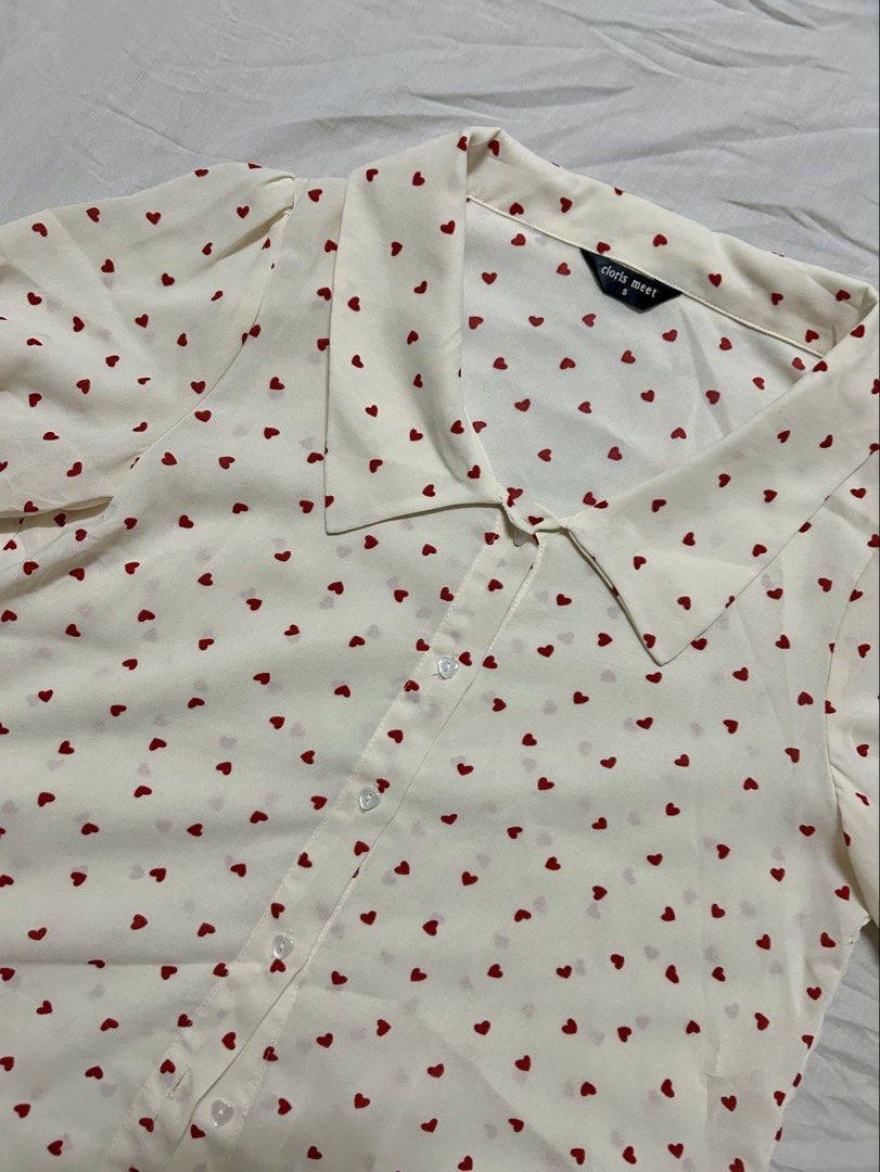 Polka-Heart Blouse (Category: Blouses) located in Quezon City. Submitted by rarefaithyyy (Listing ID 1458670292, Image 2). Description: *short-sleeve button-up blouse features a playful red heart print * thrifted expect minimal issues * size s ‼️ reminders before purchasing ‼️ - no cancellation/return/refund of orders - mop: cash/gcash/banking - mod: meet-up/j&t/lalamove - meet up or shipping every Tuesdays and Thursdays only - meet up place: Cub