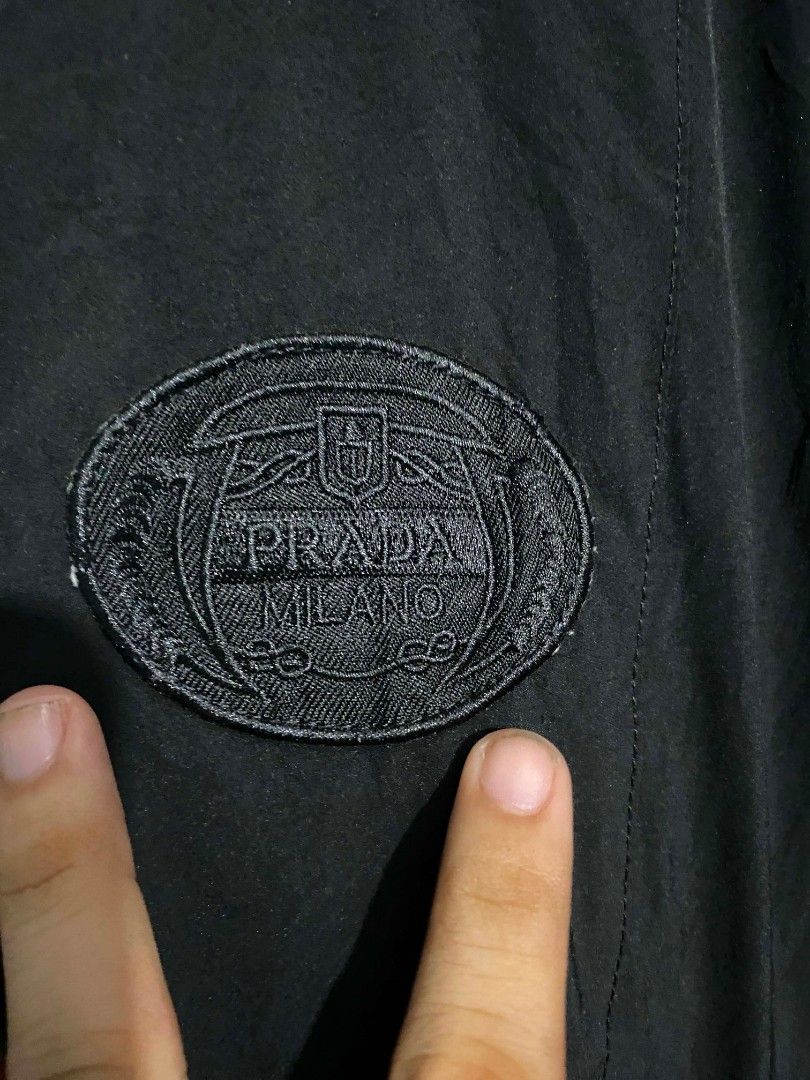 Prada Milano Black Hooded Jacket Size 50 (Category: Coats, Jackets and Outerwear) located in Manila. Submitted by jiyeee22 (Listing ID 1458664976, Image 3). Description: - Authentic black Prada hooded jacket - Size 50 - Zip closure - Iconic Prada Milano logo patch on chest - Adjustable drawstrings at hood and hem - Made in Mauritius - Please check photos for detailed condition.