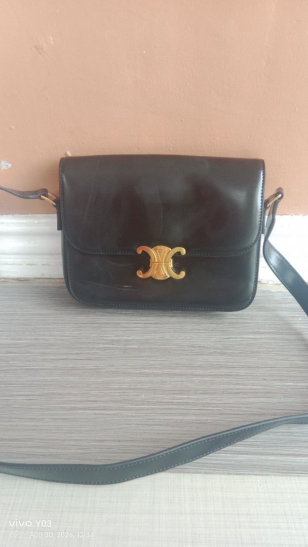 Preloved Celine Triomphe Shoulder Bag Black Leather (Category: Luxury Bags & Wallets) located in Cabuyao City. Submitted by selections888 (Listing ID 1458538369, Image 2). Description: - preloved Celine shoulder bag in black leather. - Features iconic gold-tone Triomphe clasp. - Adjustable shoulder strap for comfort. - Interior displays a subtle Celine Paris logo. - Leather shows minor signs of wear (scuffs), consistent with normal use. - Interio