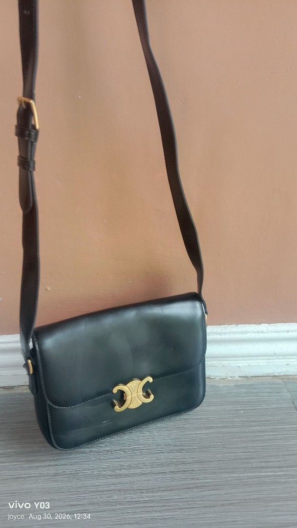 Preloved Celine Triomphe Shoulder Bag Black Leather (Category: Luxury Bags & Wallets) located in Cabuyao City. Submitted by selections888 (Listing ID 1458538369, Image 1). Description: - preloved Celine shoulder bag in black leather. - Features iconic gold-tone Triomphe clasp. - Adjustable shoulder strap for comfort. - Interior displays a subtle Celine Paris logo. - Leather shows minor signs of wear (scuffs), consistent with normal use. - Interio