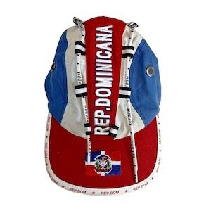 Rep. Dominicana 5 Panel Cap (Category: Caps & Hats) located in San Jose. Submitted by galitsabarat (Listing ID 1458623974, Image 2). Description: AS NEW CONDITION NO ISSUE - Cool cap representing the Dominican Republic. - Features the national flag and 'REP. DOMINICANA' text. - Adjustable strap at the back for a comfortable fit. - Unique design with drawstrings. - Perfect for showing your national pride..