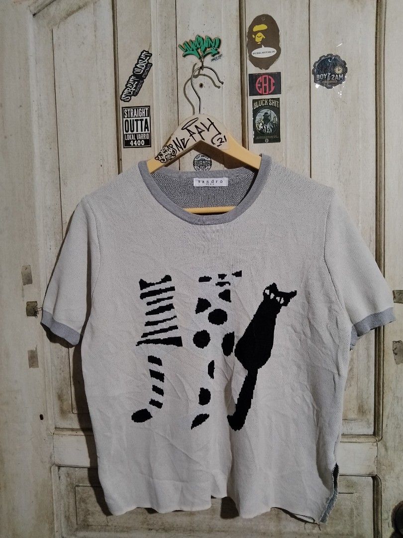 Sandro Paris T-shirt with Cat Print (Category: Shirts) located in Naga. Submitted by neppyboy (Listing ID 1458643077, Image 1). Description: - Light grey Sandro Paris t-shirt - Adorable black cat print on the front - Short sleeves with grey trim - Grey trim on the neckline - Made from comfortable knit material - Ideal for everyday casual wear.