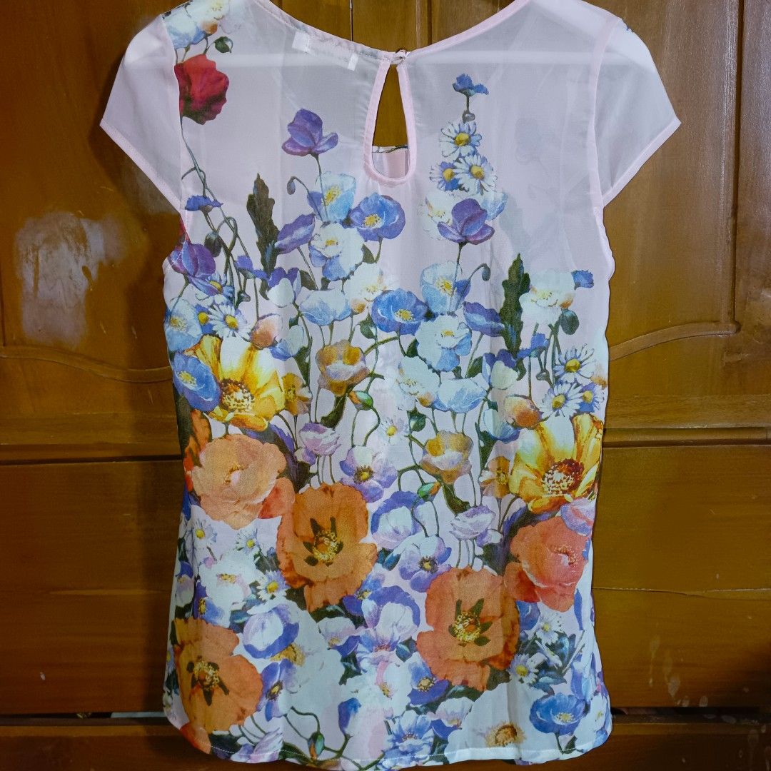 Sheer Floral Print Cap Sleeve Blouse (Category: Blouses) located in Manila. Submitted by toloveandtofold (Listing ID 1458546605, Image 2). Description: - Light pink sheer blouse - Vibrant floral print - Cap sleeves - Keyhole back closure - Lightweight and airy fabric - Versatile for casual or dressed-up looks - Easy to pair with jeans or skirts.