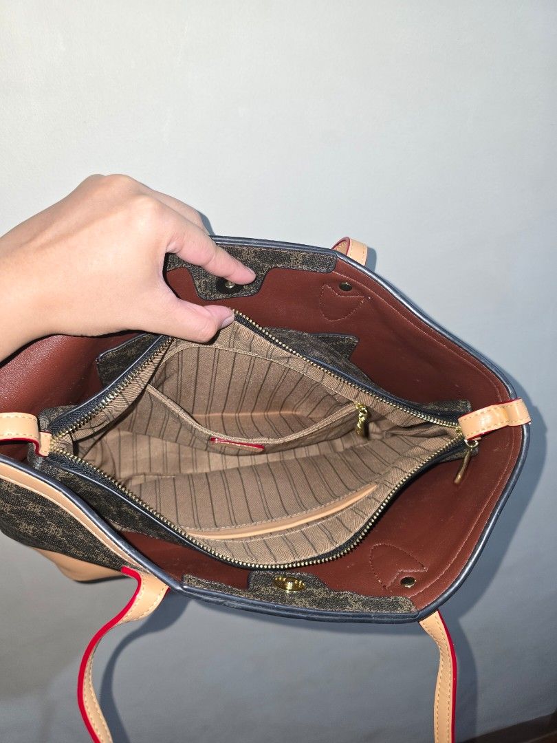Shoulder Bag with Leather Trim (Category: Tote Bags) located in Marikina City. Submitted by ynnaaaa (Listing ID 1458688849, Image 2). Description: - Classic monogram tote bag - Tan leather trim and handles - Red piping detail for a pop of color - Spacious main compartment - Interior zippered compartment and slip pockets - Ideal for everyday use or travel - Measures approximately 10 inches wide.