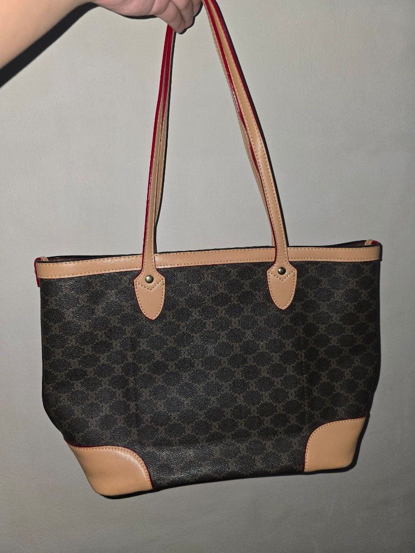 Shoulder Bag with Leather Trim (Category: Tote Bags) located in Marikina City. Submitted by ynnaaaa (Listing ID 1458688849, Image 1). Description: - Classic monogram tote bag - Tan leather trim and handles - Red piping detail for a pop of color - Spacious main compartment - Interior zippered compartment and slip pockets - Ideal for everyday use or travel - Measures approximately 10 inches wide.