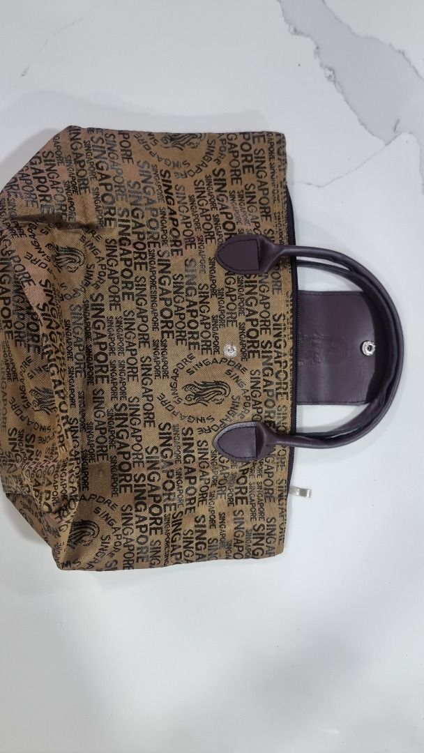 Singapore Themed Tote Bag (Category: Tote Bags) located in Paranaque City. Submitted by olxph_668280920 (Listing ID 1458562138, Image 1). Description: - Stylish brown tote bag with all-over 'Singapore' print. - Comfortable brown handles for easy carrying. - Secure snap closure for quick access. - Zipper closure at the top for added security. - Sleek black interior. - Ideal for carrying your daily essentials..