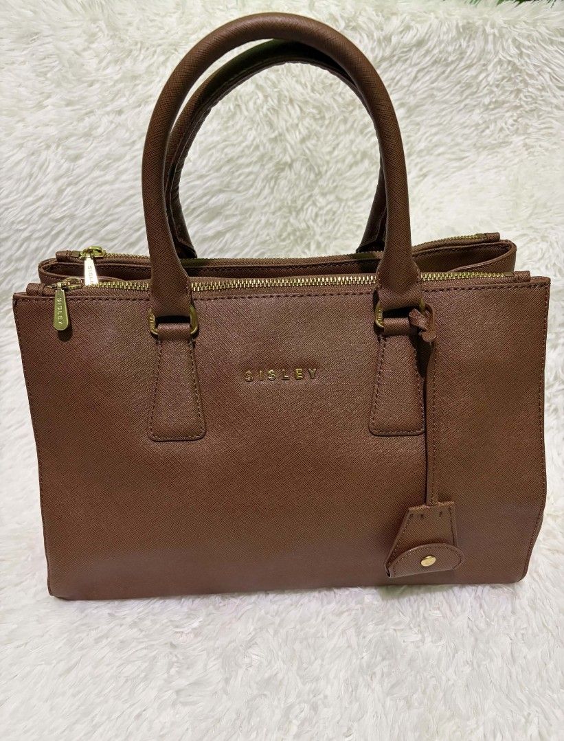 Sisley Brown Textured Tote Bag (Category: Tote Bags) located in Manila. Submitted by niklaus_12345 (Listing ID 1458557574, Image 1). Description: - Brown textured tote bag by Sisley - Elegant gold hardware details - Secure zipper closure - Interior lined with Sisley logo - Spacious and ideal for everyday use.