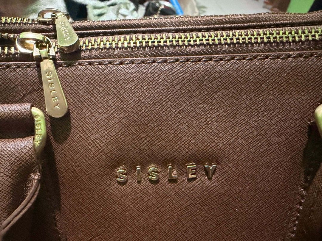 Sisley Brown Textured Tote Bag (Category: Tote Bags) located in Manila. Submitted by niklaus_12345 (Listing ID 1458557574, Image 2). Description: - Brown textured tote bag by Sisley - Elegant gold hardware details - Secure zipper closure - Interior lined with Sisley logo - Spacious and ideal for everyday use.