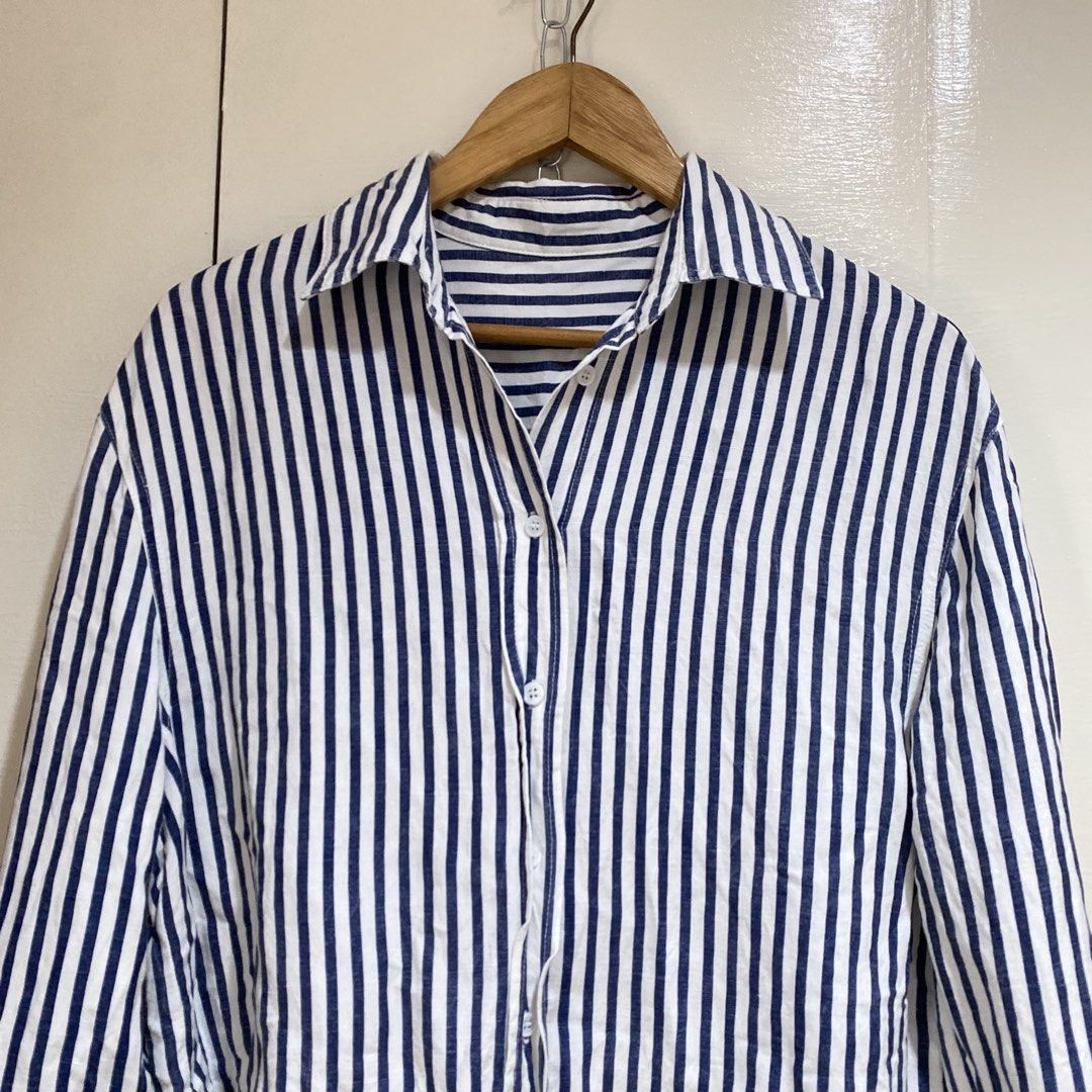 Striped Button-Up Shirt (Category: Tshirts & Polo Shirts ) located in Cavite. Submitted by branchee_chic (Listing ID 1458579265, Image 2). Description: - Classic blue and white striped pattern - Long sleeves with button cuffs - Pointed collar - Relaxed fit - Versatile for casual wear or layering - Pairs well with jeans or trousers.