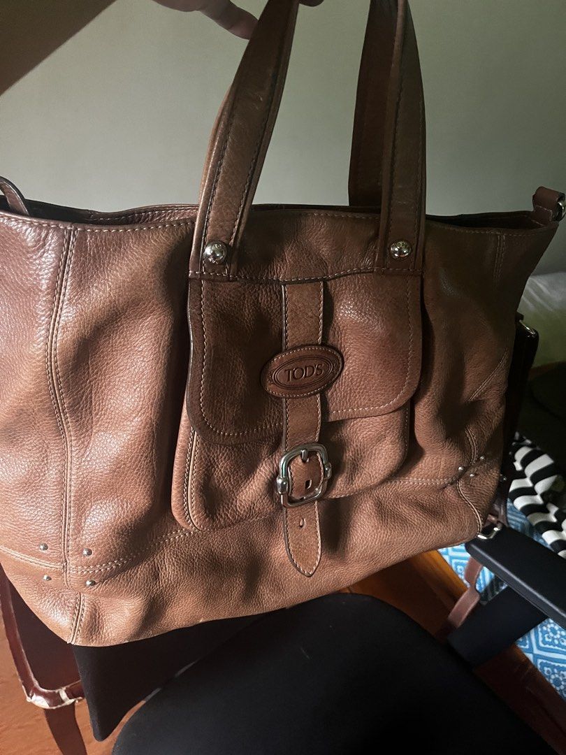 TOD'S Brown Leather Tote Bag (Category: Luxury Bags & Wallets) located in San Pedro. Submitted by vaststone.c9f0a2 (Listing ID 1458572246, Image 1). Description: - Classic brown leather tote by TOD'S - Roomy interior for all your essentials - Features a front flap pocket with buckle closure - Studded details along the bottom - Comfortable shoulder straps - Great everyday bag.
