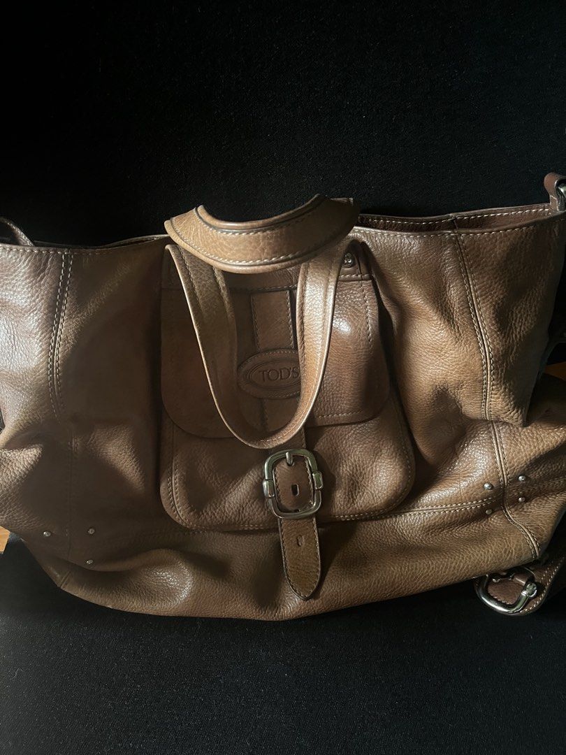 TOD'S Brown Leather Tote Bag (Category: Luxury Bags & Wallets) located in San Pedro. Submitted by vaststone.c9f0a2 (Listing ID 1458572246, Image 2). Description: - Classic brown leather tote by TOD'S - Roomy interior for all your essentials - Features a front flap pocket with buckle closure - Studded details along the bottom - Comfortable shoulder straps - Great everyday bag.