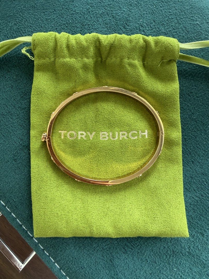 Tory Burch Gold Tone Logo Bangle Bracelet (Category: Bracelets) located in Quezon City. Submitted by adelly23 (Listing ID 1458559555, Image 1). Description: Gold Tory Burch bangle with all-around logo. Includes original pouch with receipt. Perfect accessory for easy styling. Used twice only. Pristine condition. Price is negotiable just make an offer..