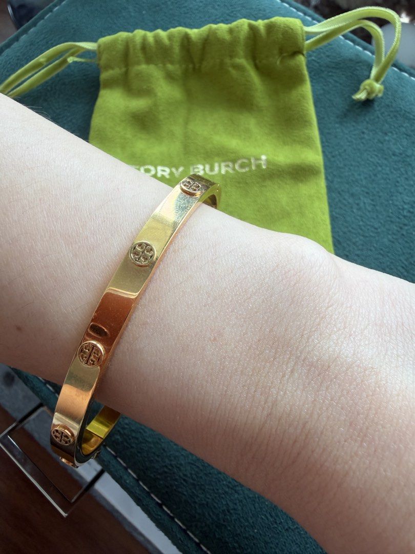 Tory Burch Gold Tone Logo Bangle Bracelet (Category: Bracelets) located in Quezon City. Submitted by adelly23 (Listing ID 1458559555, Image 3). Description: Gold Tory Burch bangle with all-around logo. Includes original pouch with receipt. Perfect accessory for easy styling. Used twice only. Pristine condition. Price is negotiable just make an offer..