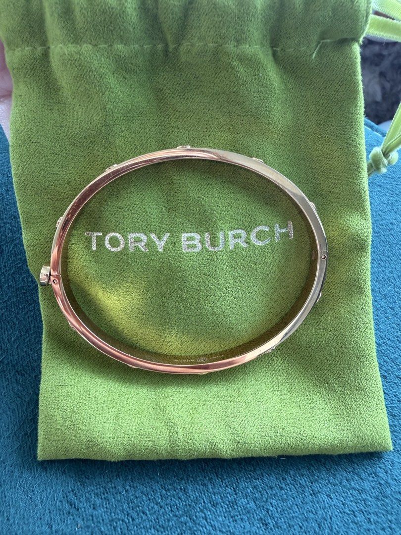 Tory Burch Gold Tone Logo Bangle Bracelet (Category: Bracelets) located in Quezon City. Submitted by adelly23 (Listing ID 1458559555, Image 2). Description: Gold Tory Burch bangle with all-around logo. Includes original pouch with receipt. Perfect accessory for easy styling. Used twice only. Pristine condition. Price is negotiable just make an offer..
