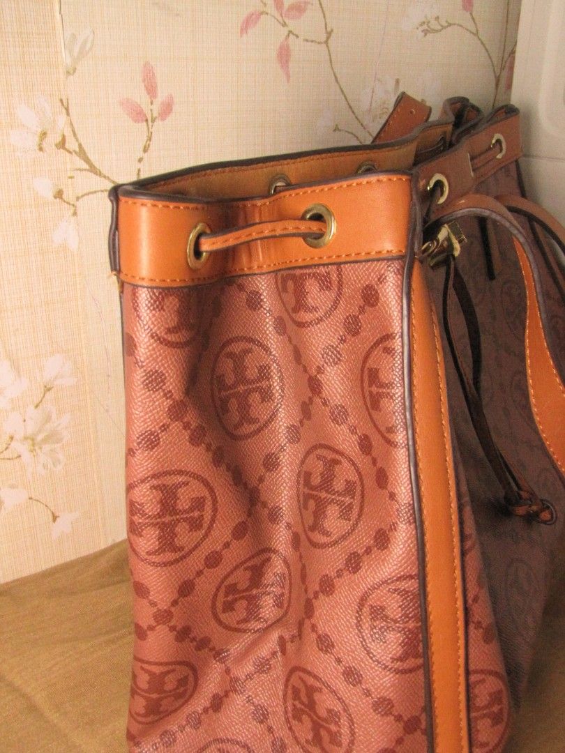 Tory Burch Monogram Tote Bag (Category: Luxury Bags & Wallets) located in Manila. Submitted by puddybab_m1 (Listing ID 1458571082, Image 3). Description: MAY FLAW, BAWAL SA MAARTE, NEEDS CLEANING RIN PO AND REPAIR. BAG IS STYLISH PERO NEED PO MAFIX AND CLEAN - Authentic Tory Burch tote bag in brown. - Features an all-over signature monogram print. - Accented with elegant leather trim and handles. - Secure and stylish drawstring closure. - Adorned
