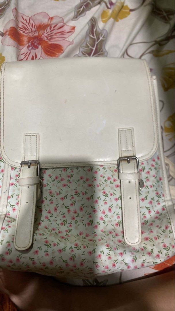 White Floral Backpack (Category: Backpacks) located in Manila. Submitted by annbrnld (Listing ID 1458614230, Image 1). Description: - Cute white backpack with a light blue floral print. - Two adjustable buckle straps on the front flap. - Interior pockets for organization. - Ideal for school or casual outings. - Shows some minor marks on the white flap..