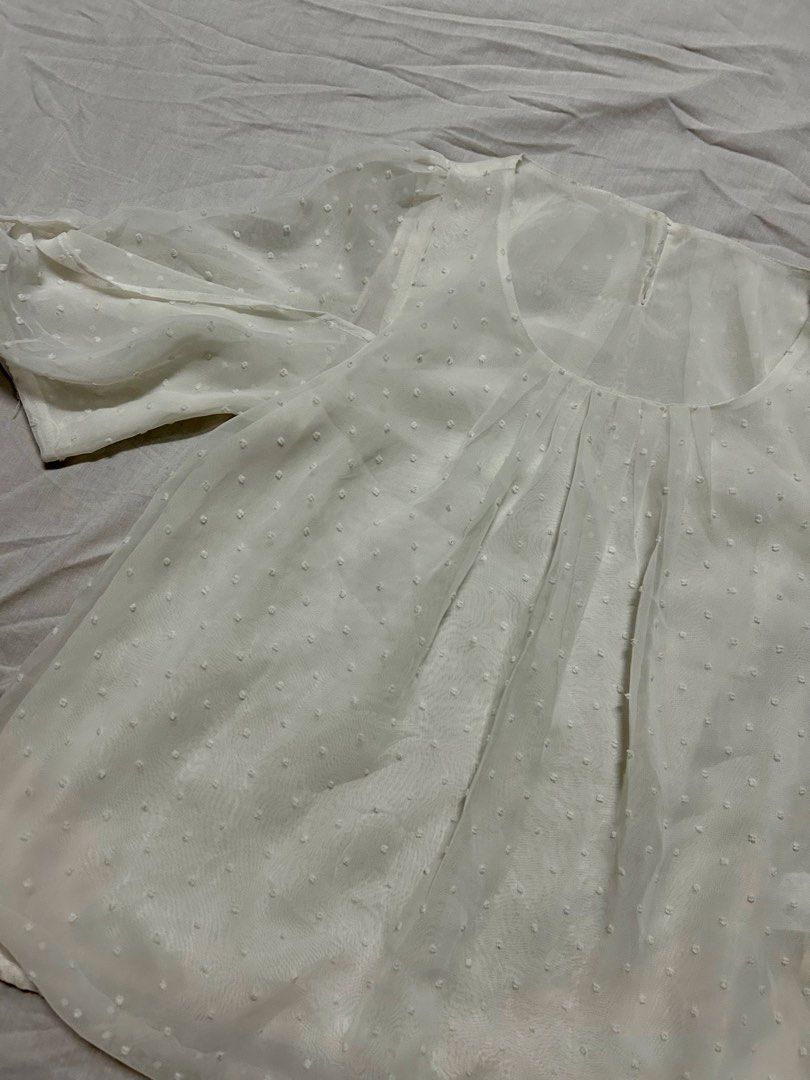 White sheer Swiss dot blouse (Category: Blouses) located in Quezon City. Submitted by rarefaithyyy (Listing ID 1458671472, Image 2). Description: - White sheer blouse - Features Swiss dot pattern - Size: Small (S) to Medium (M) - Condition: Excellent * thrifted expect minimal issues ‼️ reminders before purchasing ‼️ - no cancellation/return/refund of orders - mop: cash/gcash/banking - mod: meet-up/j&t/lalamove - meet up or shipping every Tuesdays