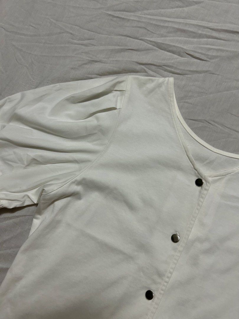 White V-Neck Short-Sleeve Blouse (Category: Blouses) located in Quezon City. Submitted by rarefaithyyy (Listing ID 1458672566, Image 3). Description: - White V-neck short-sleeve blouse - Size: S (EU 36/UK 8/US 4) - Features puff sleeves - Button-down front detail - Versatile and stylish * thrifted expect minimal issues ‼️ reminders before purchasing ‼️ - no cancellation/return/refund of orders - mop: cash/gcash/banking - mod: meet-up/j&t/lalamove