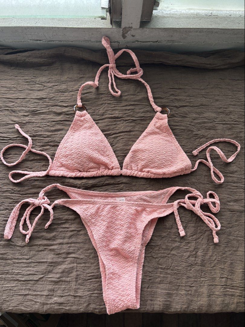 XS Pink Textured Triangle Bikini Set (Category: Bikinis & Swimsuits) located in Muntinlupa City. Submitted by jc444_ (Listing ID 1458677480, Image 1). Description: - Adorable pink bikini set - Textured fabric all over - Adjustable ties at neck and sides for a perfect fit - Chic ring details on bikini top straps - Tie-side bottoms for customizable comfort - Ideal for your next beach or pool day.