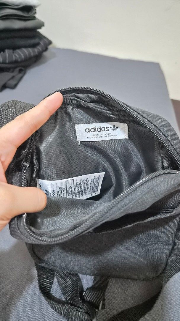 Adidas Crossbody Bag with Drip Logo (Category: Cross-body Bags) located in Pasig City. Submitted by bash0011 (Listing ID 1458778814, Image 2). Description: - Black Adidas crossbody bag - Features classic Adidas logo with a cool drip effect design on the front flap - Adjustable strap for comfortable wear - Main compartment with zipper closure - Small pocket inside - Ideal for carrying your daily essentials.