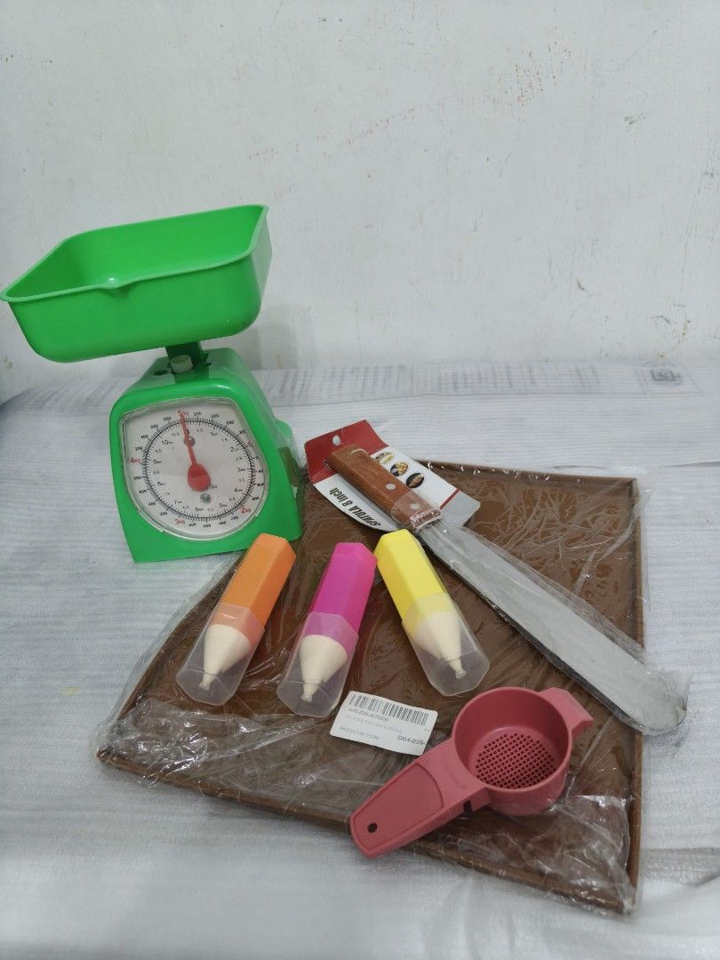Baking Set (A) (Category: Other Kitchen Appliances) located in Masai. Submitted by Ready_to_go (Listing ID 1458709549, Image 1). Description: - Green kitchen scale - Pink sieve - Bread knife - 3 pencil-shaped molds (orange, pink, yellow) - Ideal for baking and cooking enthusiasts .