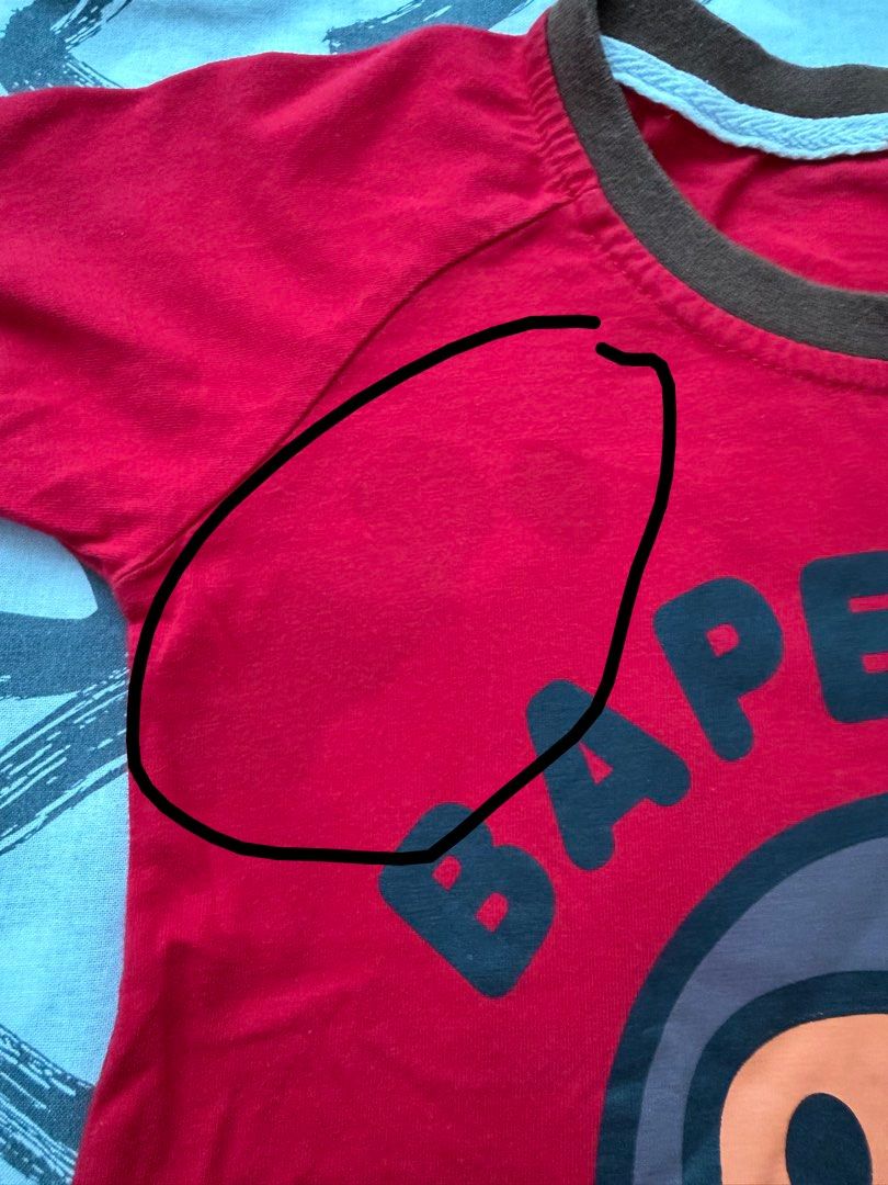 BAPE Kids Shirt (Category: Babies & Kids Fashion) located in Pasig City. Submitted by fancytracy (Listing ID 1458706716, Image 3). Description: Flaw: Stain (right upper part),2 small holes. Refer to photo Disclaimer Can’t guarantee the authenticity since these are hand me downs.