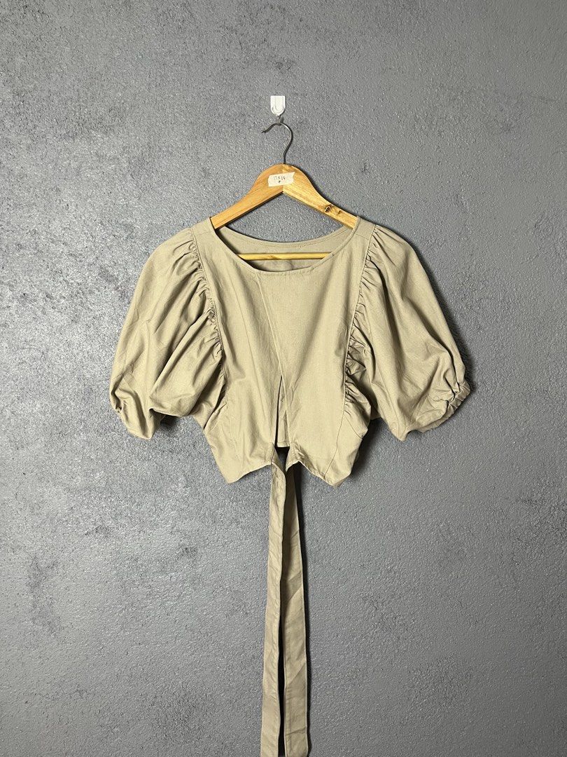 Beige Puff Sleeve Tie Back Crop Top (Category: Blouses) located in Famy. Submitted by basicthrifted (Listing ID 1458728216, Image 1). Description: - Cute beige crop top - Features stylish puff sleeves - Adjustable tie-back detail - Comfortable cotton blend fabric - Versatile for casual outings or dressing up - Pairs perfectly with high-waisted bottoms.