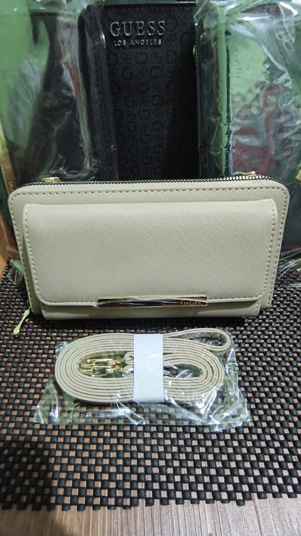 SILFIEL Beige Wallet with Gold Accent and Strap (Category: Luxury Bags & Wallets) located in Manila. Submitted by akosijapok (Listing ID 1458732541, Image 3). Description: SILFIEL 2-Way Crossbody Wallet & Smartphone Bag. It features a beige saffiano-style faux leather finish, a front flap pocket with a gold-tone accent bar, a zip-around main compartment, and a matching detachable shoulder strap. - Stylish beige wallet clutch - Secure zip-around c