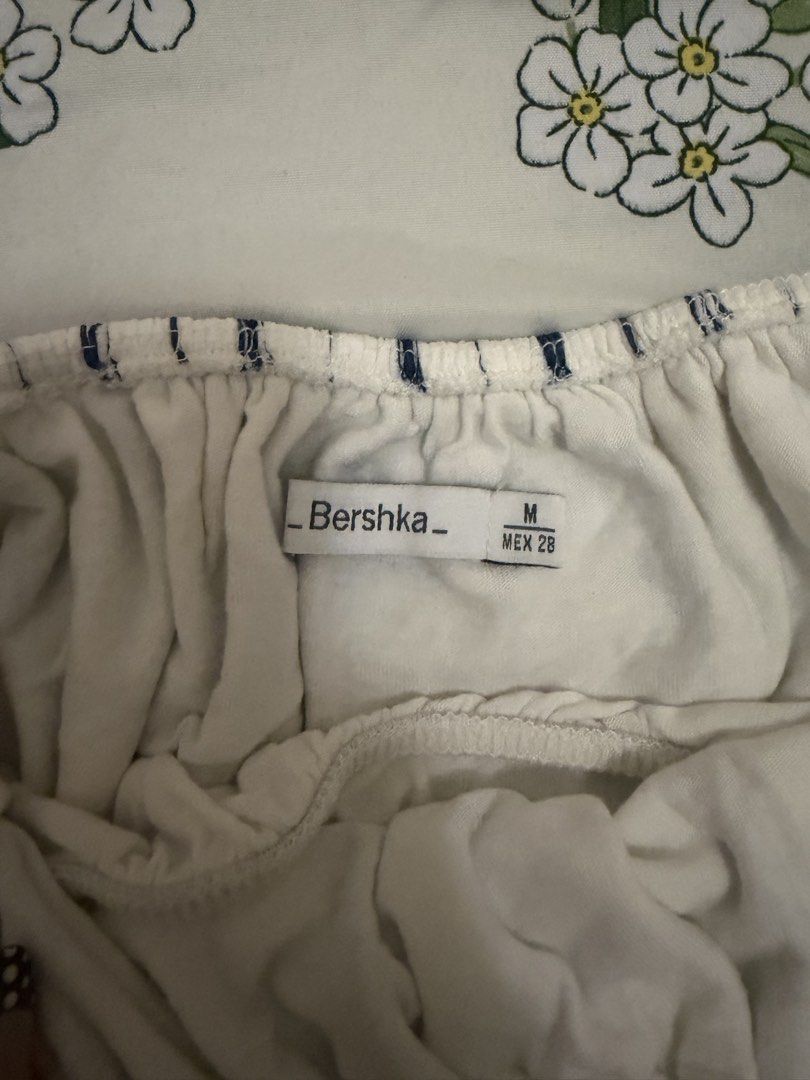Bershka Off-Shoulder Striped Crop Top (Category: Blouses) located in Quezon City. Submitted by michaella.r (Listing ID 1458814970, Image 2). Description: - White and blue striped off-shoulder top - Elasticated neckline and sleeves for a comfy fit - Cropped length with a flowy silhouette - Perfect for pairing with high-waisted jeans or skirts - Size: Medium (M).