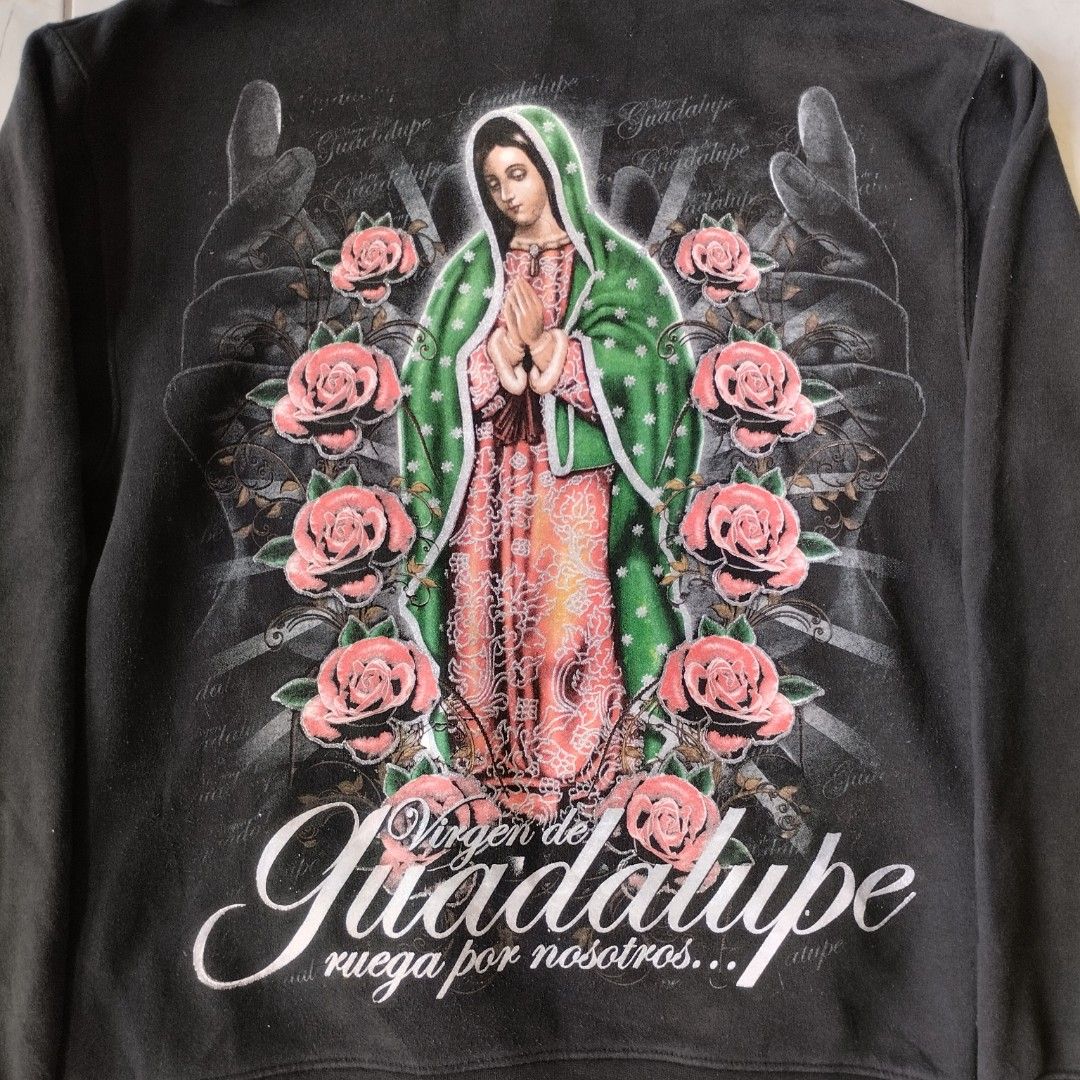 Black Virgen de Guadalupe Hoodie (Category: Hoodies) located in Tagaytay City. Submitted by santino_rio (Listing ID 1458778849, Image 3). Description: - Classic black hoodie - Large, detailed Virgen de Guadalupe graphic on back - Smaller graphic on front - Graphic features roses and praying hands - Comfortable kangaroo pocket - Adjustable drawstring hood - Perfect for fans of this unique style - 22x28 dimes.