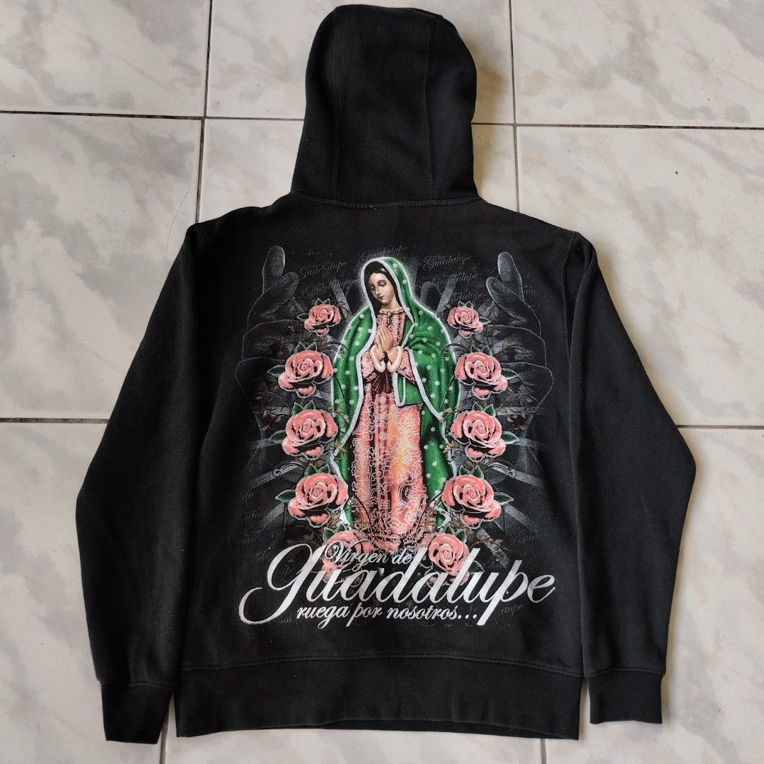 Black Virgen de Guadalupe Hoodie (Category: Hoodies) located in Tagaytay City. Submitted by santino_rio (Listing ID 1458778849, Image 1). Description: - Classic black hoodie - Large, detailed Virgen de Guadalupe graphic on back - Smaller graphic on front - Graphic features roses and praying hands - Comfortable kangaroo pocket - Adjustable drawstring hood - Perfect for fans of this unique style - 22x28 dimes.