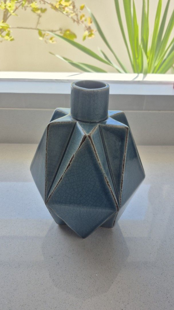 Blue Ceramic Vase (Category: Vases & Decorative Bowls) located in Binan City. Submitted by nicegaragesale (Listing ID 1458759255, Image 1). Description: - Unique geometric design - Stunning teal blue crackle glaze - Perfect for dried flowers or as a standalone decor piece - Adds a modern touch to shelves and tables - Dimensions: Approx. X inches tall, Y inches wide.