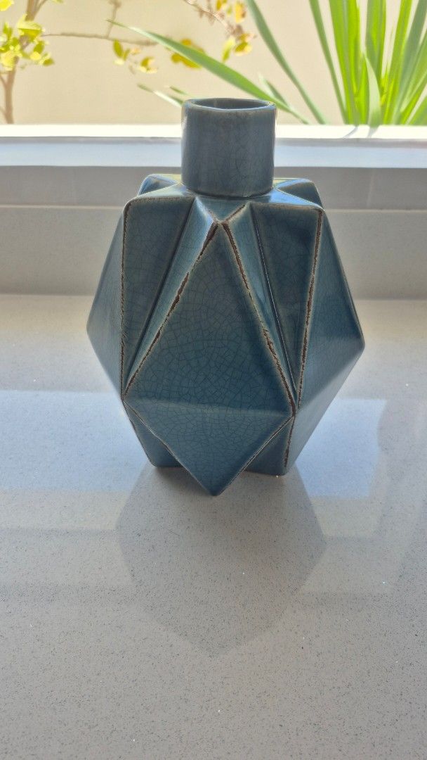 Blue Ceramic Vase (Category: Vases & Decorative Bowls) located in Binan City. Submitted by nicegaragesale (Listing ID 1458759255, Image 3). Description: - Unique geometric design - Stunning teal blue crackle glaze - Perfect for dried flowers or as a standalone decor piece - Adds a modern touch to shelves and tables - Dimensions: Approx. X inches tall, Y inches wide.