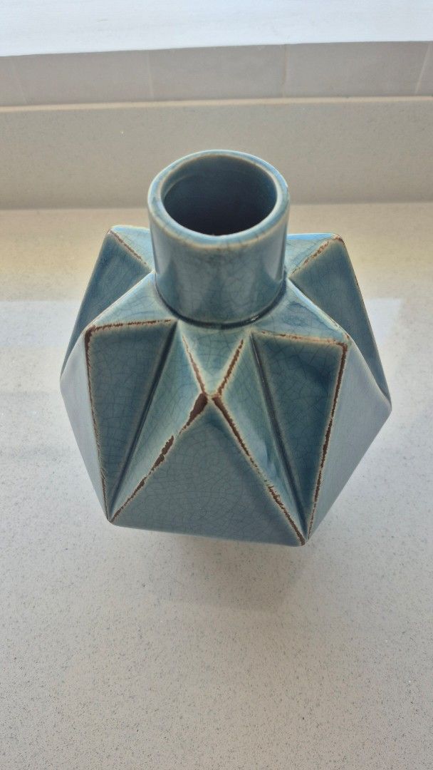 Blue Ceramic Vase (Category: Vases & Decorative Bowls) located in Binan City. Submitted by nicegaragesale (Listing ID 1458759255, Image 2). Description: - Unique geometric design - Stunning teal blue crackle glaze - Perfect for dried flowers or as a standalone decor piece - Adds a modern touch to shelves and tables - Dimensions: Approx. X inches tall, Y inches wide.