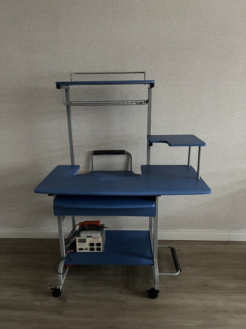 Blue Rolling Computer Desk with Shelves and Keyboard Tray (Category: Tables & Sets) located in Manila. Submitted by lorymingui15824 (Listing ID 1458774522, Image 2). Description: - Blue rolling computer desk - Pull-out keyboard tray - Multiple shelves for storage - Top shelf with wire rack - On wheels for easy movement - Ideal for small workspaces or dorm rooms - Minor scuffs on frame from use.