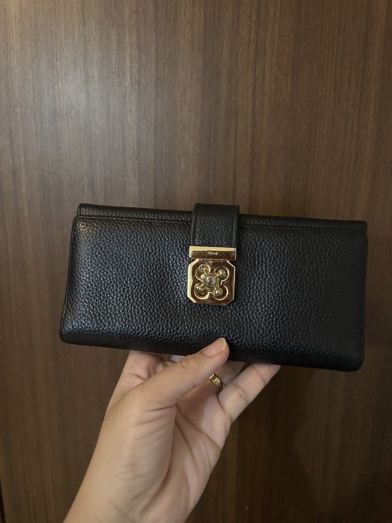 Chloe Black Leather Long Wallet (Category: Luxury Bags & Wallets) located in Batangas. Submitted by jhinp0t (Listing ID 1458772932, Image 1). Description: - Genuine Leather Chloe black pebbled leather long wallet -Ykk zipper - Elegant gold-tone clasp closure with decorative stones - Multiple interior card slots for easy organization - Secure zippered compartment for coins or receipts - Subtle embossed Chloe logo inside.