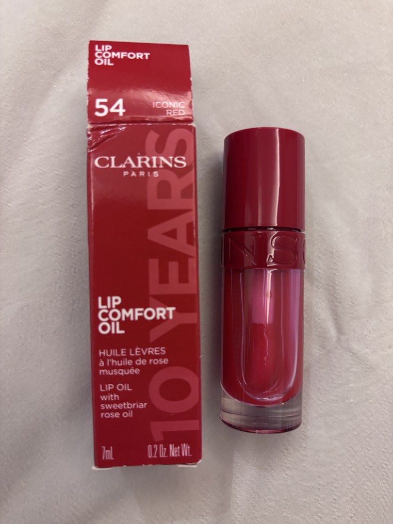 Clarins Lip Comfort Oil (Category: Makeup) located in Pasig City. Submitted by missclosetcleanup (Listing ID 1458804842, Image 1). Description: - Clarins Lip Comfort Oil - Shade: 54 Iconic Red - Size: 7ml / 0.2 Oz. Net Wt. - Enriched with Sweetbriar Rose Oil - Provides moisture and a subtle hint of color - "10 Years" packaging.