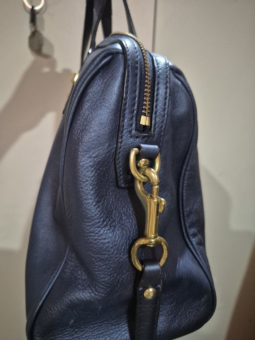 Coach Leather Handbag (Category: Luxury Bags & Wallets) located in Iloilo. Submitted by gorgeoustatz (Listing ID 1458837970, Image 3). Description: - Dark navy blue leather handbag - Elegant gold hardware details - Secure zipper closure - Comfortable top handles - Detachable shoulder strap for versatility - Comes with a stylish Coach keychain charm - Ample interior space for all your essentials - Ideal for everyday use.