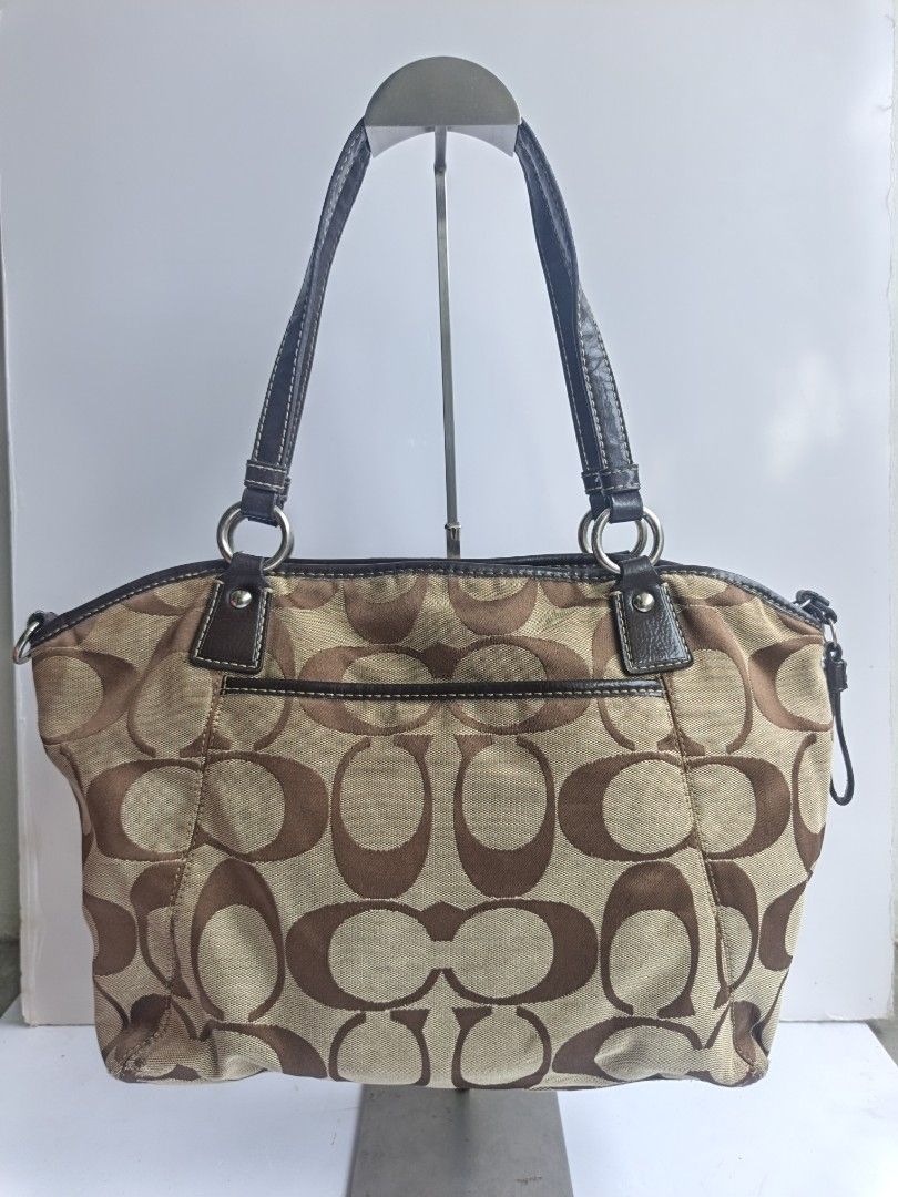 Coach Monogram Canvas Leather Trim Shoulder Bag (Category: Luxury Bags & Wallets) located in Cavite. Submitted by benta_bounce (Listing ID 1458793289, Image 2). Description: - Classic Coach monogram shoulder bag - Color: Brown and tan canvas with dark brown leather trim - Iconic Coach 'C' pattern - Features a central suede stripe - Includes Coach logo emblem - Durable leather handles - Comes with a Coach hangtag - Spacious interior for essentials