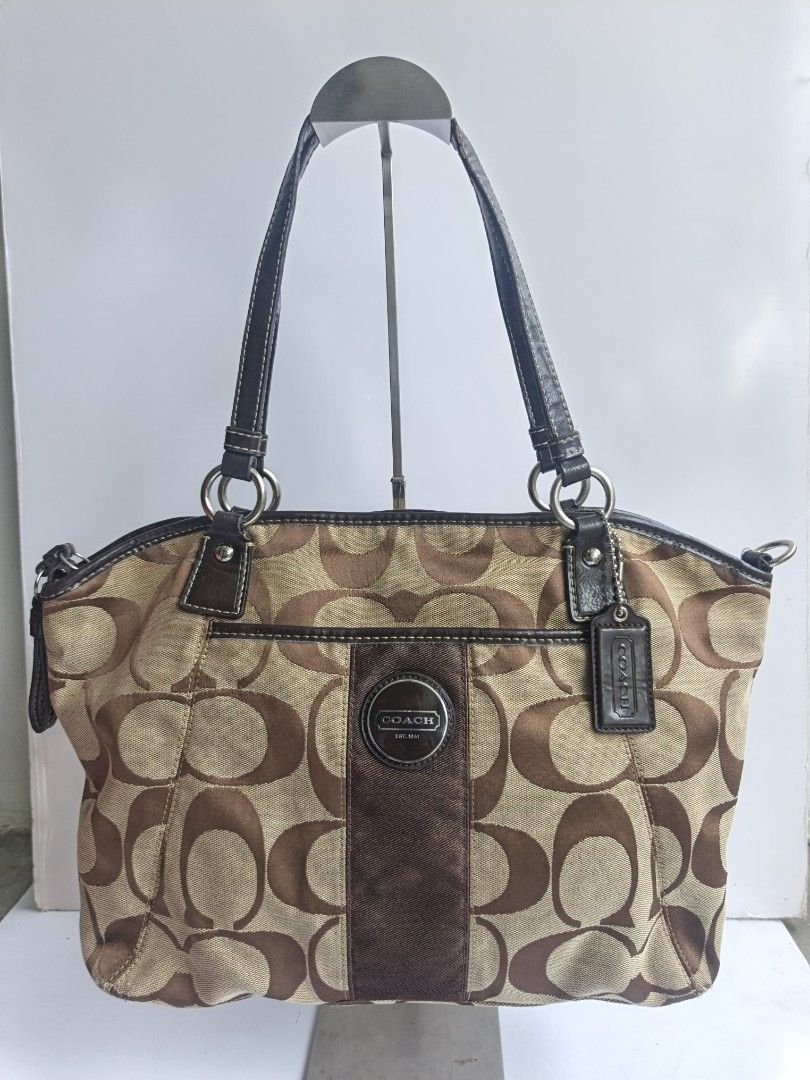Coach Monogram Canvas Leather Trim Shoulder Bag (Category: Luxury Bags & Wallets) located in Cavite. Submitted by benta_bounce (Listing ID 1458793289, Image 1). Description: - Classic Coach monogram shoulder bag - Color: Brown and tan canvas with dark brown leather trim - Iconic Coach 'C' pattern - Features a central suede stripe - Includes Coach logo emblem - Durable leather handles - Comes with a Coach hangtag - Spacious interior for essentials