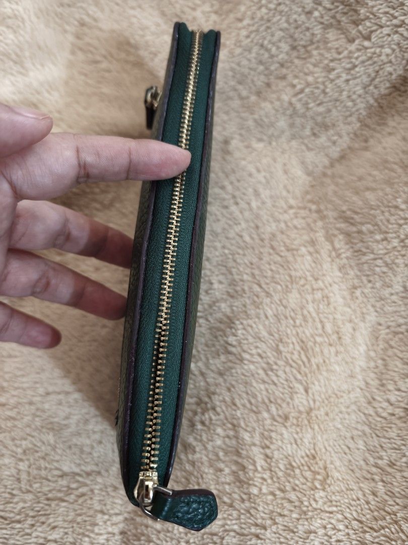 Dark Green Leather Zip Around Wallet (Category: Wallets & Card holders) located in Tanza. Submitted by declutterolshoppe (Listing ID 1458729947, Image 3). Description: - Classic dark green leather wallet - Textured leather finish - Zip-around closure (slight issue zipper) - Front zippered pocket - Multiple interior card slots and compartments - Gold-tone hardware.