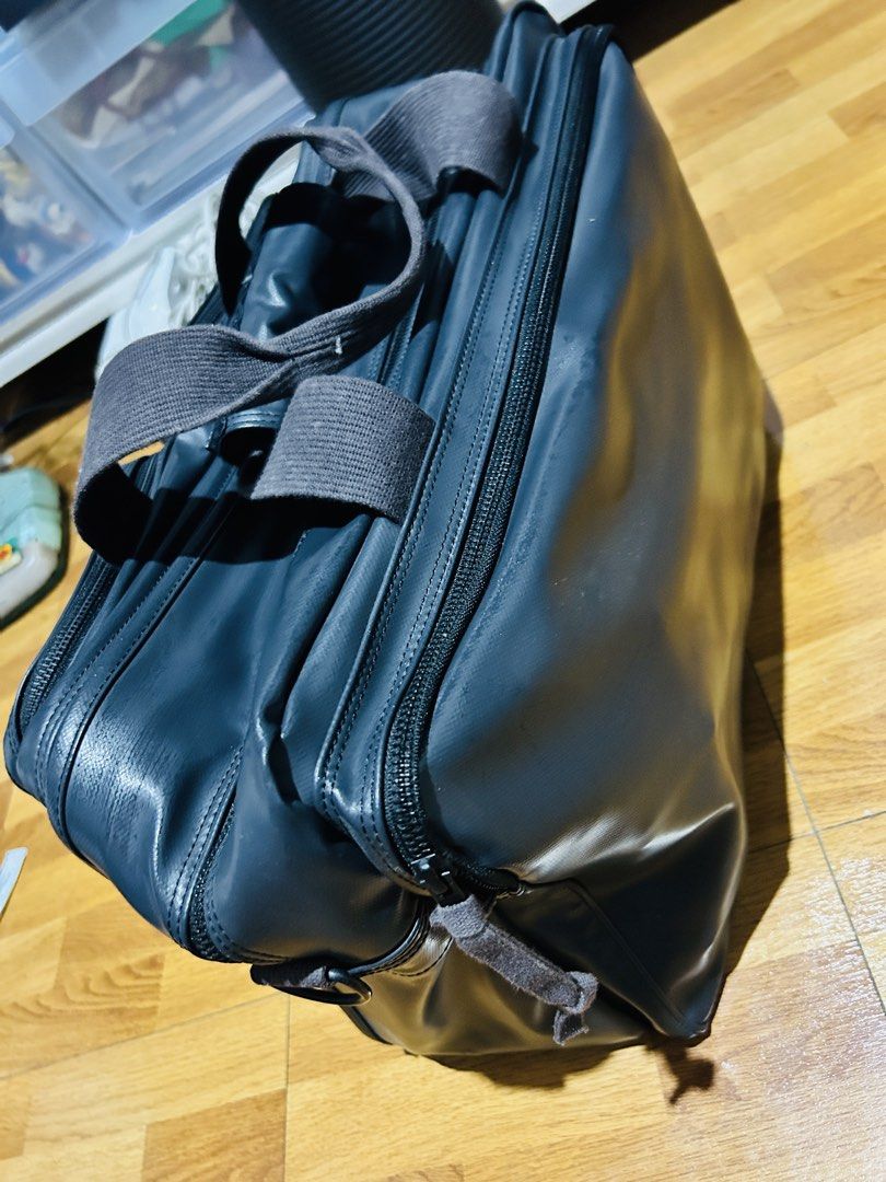 Dark Grey Multi-Pocket Travel Bag with Logo (Category: Sling Bags) located in Manila. Submitted by mr.helpmeclean (Listing ID 1458785338, Image 3). Description: - Dark grey travel bag - Multiple zippered compartments for organization - Red and white logo patch on the front - Durable material - Comfortable carry handles - Perfect for trips or daily use.