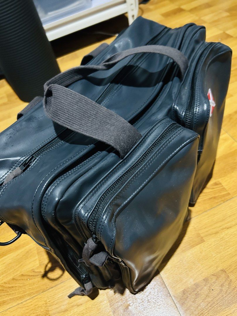 Dark Grey Multi-Pocket Travel Bag with Logo (Category: Sling Bags) located in Manila. Submitted by mr.helpmeclean (Listing ID 1458785338, Image 2). Description: - Dark grey travel bag - Multiple zippered compartments for organization - Red and white logo patch on the front - Durable material - Comfortable carry handles - Perfect for trips or daily use.