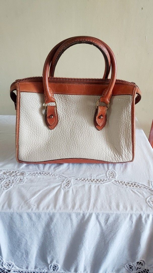 Dooney & Bourke Leather Satchel Bag (Category: Luxury Bags & Wallets) located in Cavite. Submitted by bonita2230 (Listing ID 1458740786, Image 2). Description: - Classic Dooney & Bourke satchel - Pebble leather with tan leather trim and handles - Secure zipper closure - Multiple interior compartments for organization with minor scratches - Ideal for everyday use.