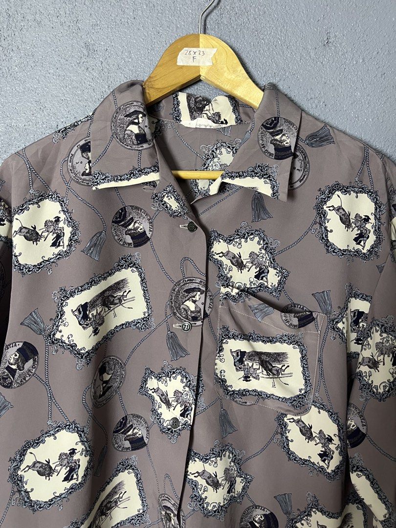 Fantaisie Vintage Button-Up Shirt (Category: Tshirts & Polo Shirts ) located in Famy. Submitted by basicthrifted (Listing ID 1458728039, Image 2). Description: - Vintage Un Brin De Fantaisie button-up shirt - Unique all-over print: frames, chains, and figures - Classic collar and button-down front - Estimated Size: F (Please check measurements) - Measurements: 28 inches (length) x 23 inches (width) - Ideal for achieving a retro aesthetic.
