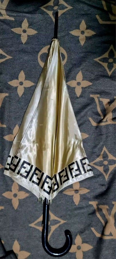 Fendi Monogram Umbrella (Category: Luxury Accessories) located in Legazpi City. Submitted by rhumbalagu04057 (Listing ID 1458690606, Image 1). Description: - Authentic vintage Fendi umbrella - Iconic Fendi FF monogram pattern on the trim - Wooden handle with metal Fendi logo - Subtle Fendi pattern woven into the fabric - Comes with original Fendi branded band for closure.